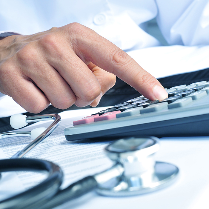 bullet img hand on calculator next to stethoscope
